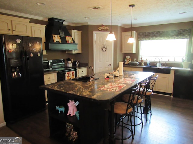 kitchen featuring premium range hood, a kitchen island, sink, and black appliances