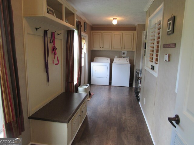 laundry area with dark wood-type flooring, cabinets, crown molding, and washer and clothes dryer