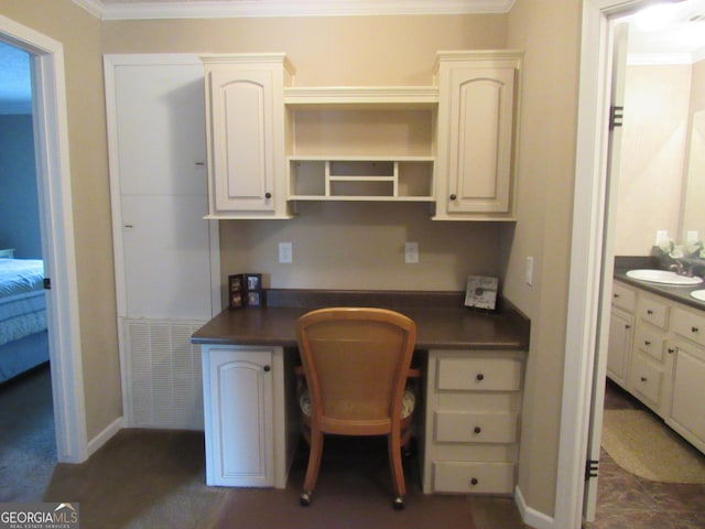 office area with sink, built in desk, and ornamental molding