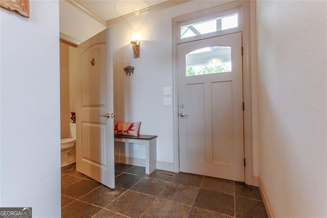 tiled foyer entrance featuring crown molding