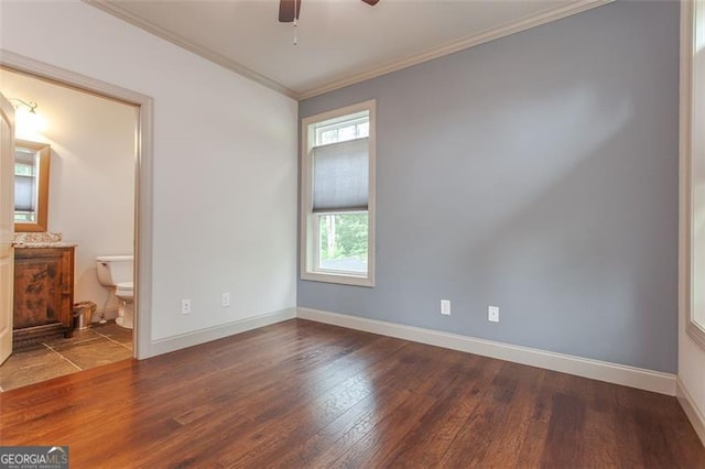 unfurnished bedroom with ornamental molding, ensuite bath, wood-type flooring, and ceiling fan