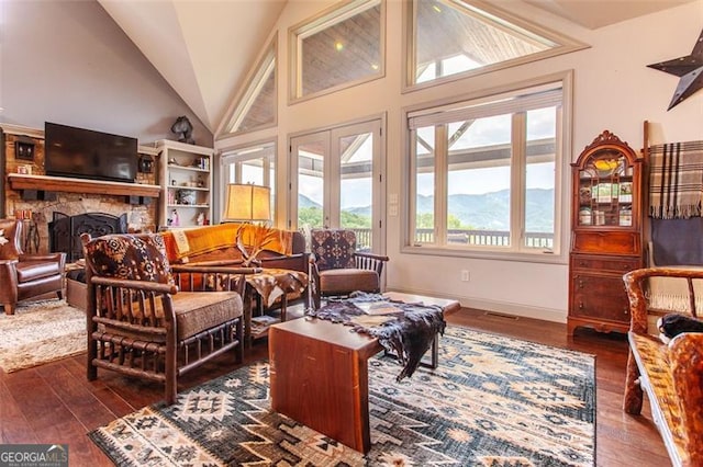 living room with a mountain view, dark hardwood / wood-style flooring, a fireplace, and high vaulted ceiling