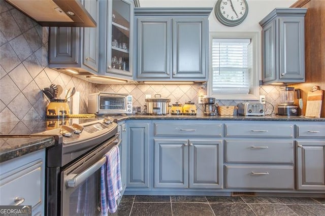 kitchen featuring range with electric stovetop, dark tile patterned floors, premium range hood, and tasteful backsplash