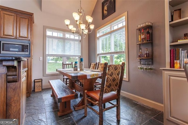 tiled dining space featuring lofted ceiling, built in features, a wealth of natural light, and an inviting chandelier