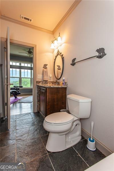 bathroom with tile patterned flooring, toilet, vanity, ceiling fan, and ornamental molding