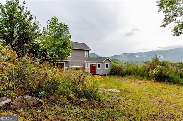 view of yard with a mountain view and a storage shed