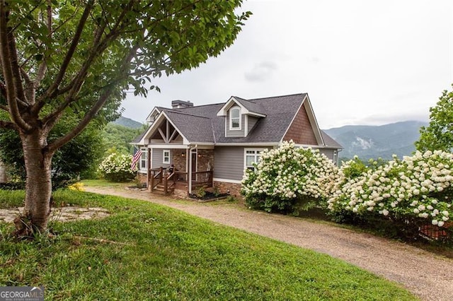 view of front of home with a mountain view and a front lawn