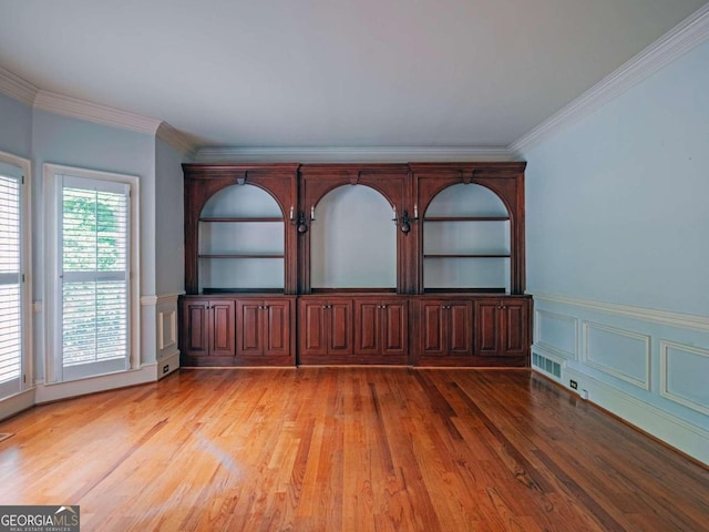 spare room featuring hardwood / wood-style flooring and crown molding