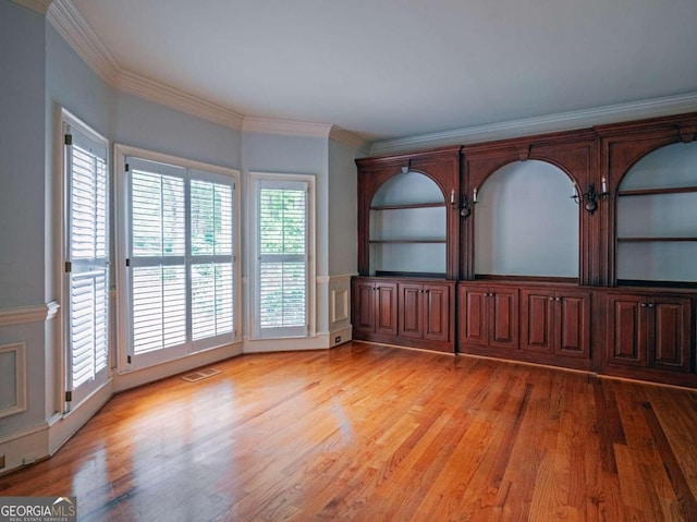 empty room featuring light hardwood / wood-style flooring and ornamental molding