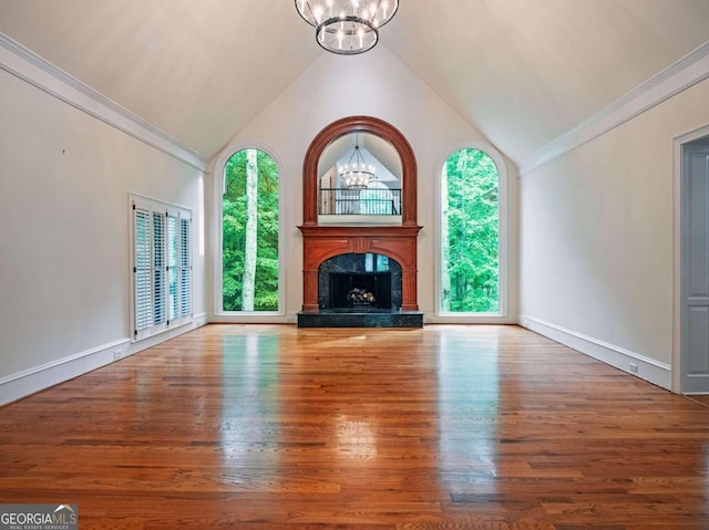 unfurnished living room featuring hardwood / wood-style floors, a wealth of natural light, and a chandelier