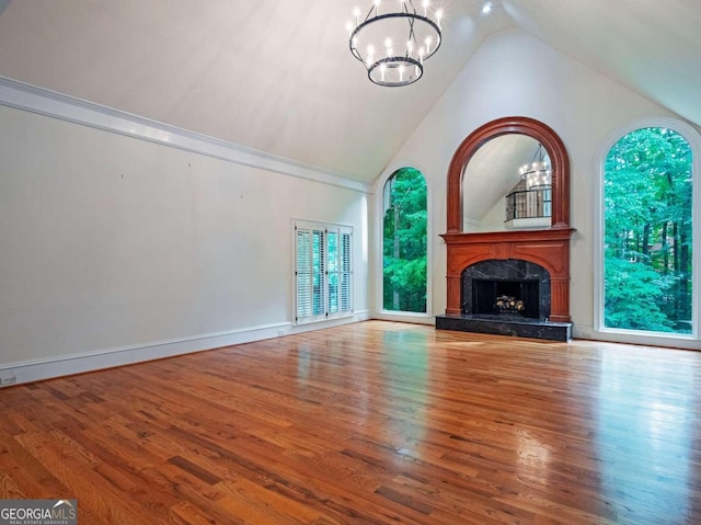 unfurnished living room with a healthy amount of sunlight, wood-type flooring, and a high end fireplace