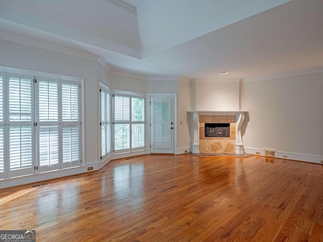 unfurnished living room featuring a fireplace, crown molding, and wood-type flooring