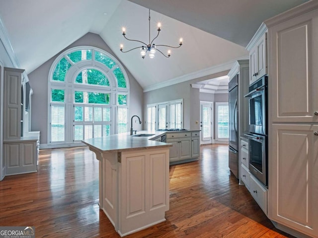 kitchen with a breakfast bar, hardwood / wood-style flooring, a center island with sink, and stainless steel appliances