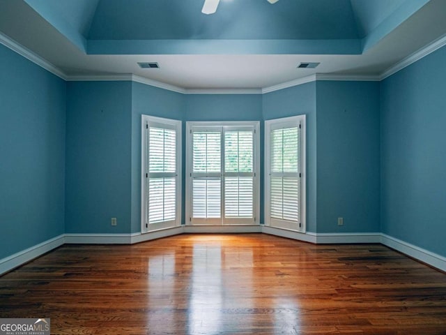 unfurnished room with ceiling fan, crown molding, a tray ceiling, and wood-type flooring