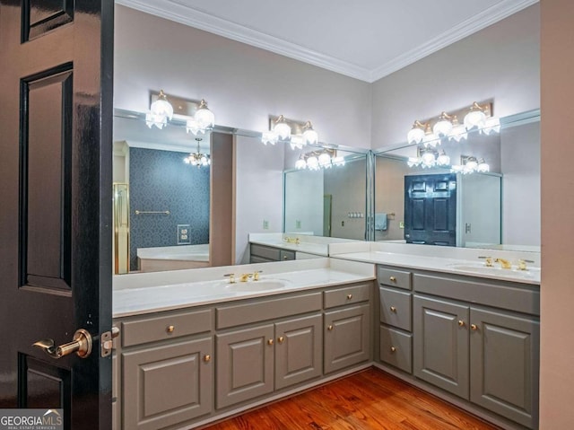 bathroom with wood-type flooring, dual vanity, and crown molding