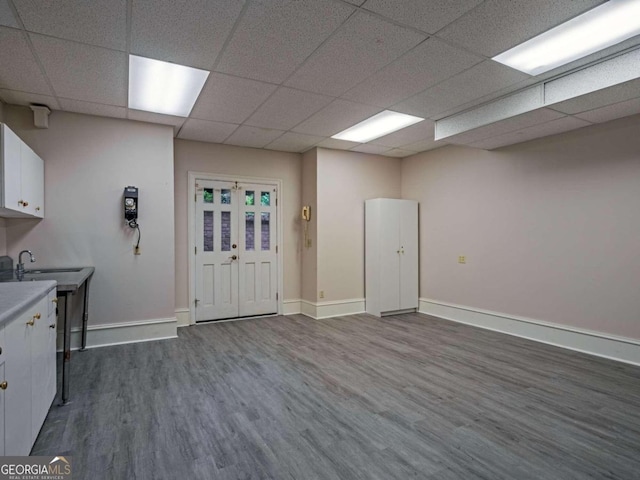 interior space with hardwood / wood-style floors, sink, and a paneled ceiling