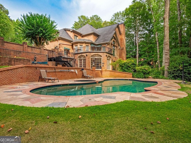 view of pool with an in ground hot tub, a yard, and a patio area