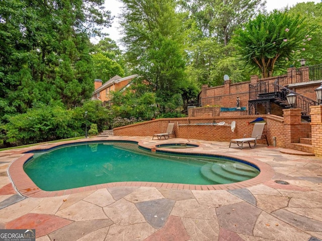 view of pool with an in ground hot tub and a patio area