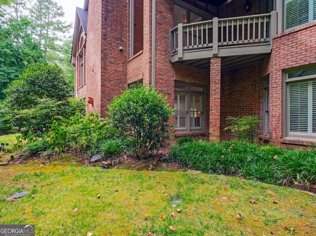 exterior space featuring a balcony and a lawn