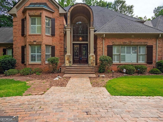 view of front facade with french doors and a front lawn