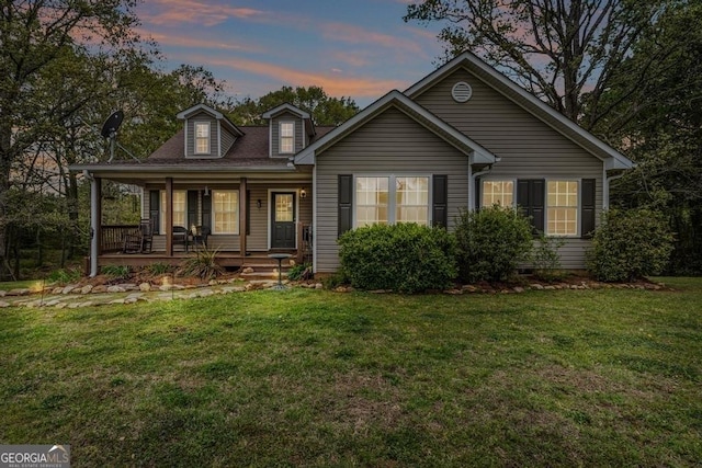 view of front facade featuring covered porch and a lawn