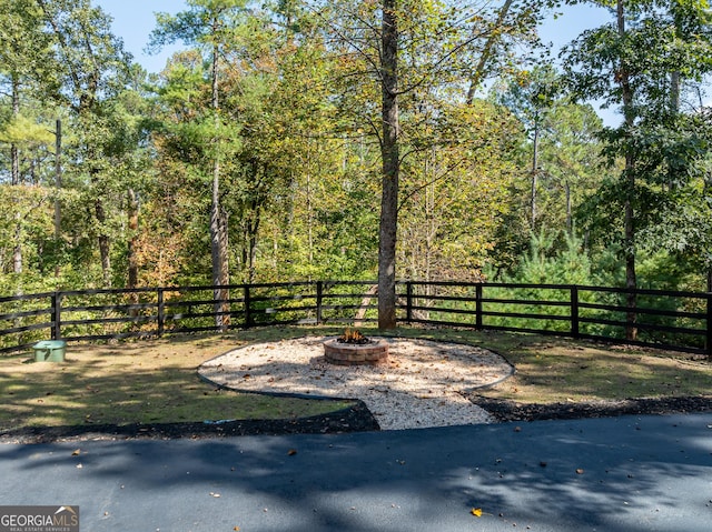 view of yard with fence and a fire pit