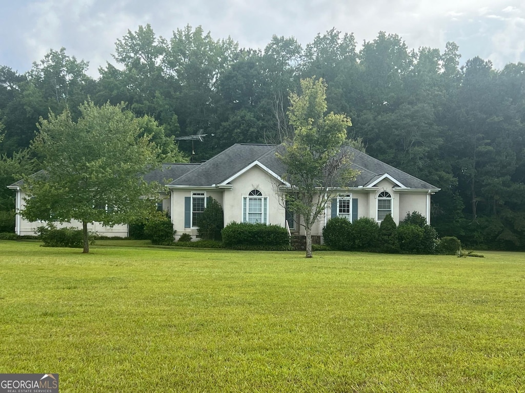 ranch-style home with stucco siding and a front lawn