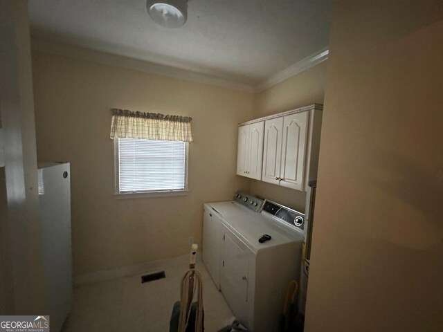 washroom with independent washer and dryer, crown molding, and cabinets