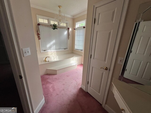 bathroom featuring a bathing tub, a notable chandelier, and ornamental molding