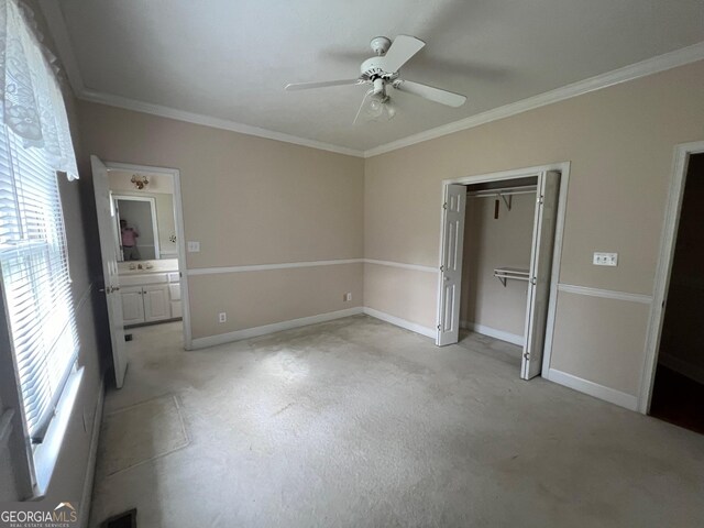 unfurnished bedroom featuring ensuite bathroom, a closet, ceiling fan, and crown molding