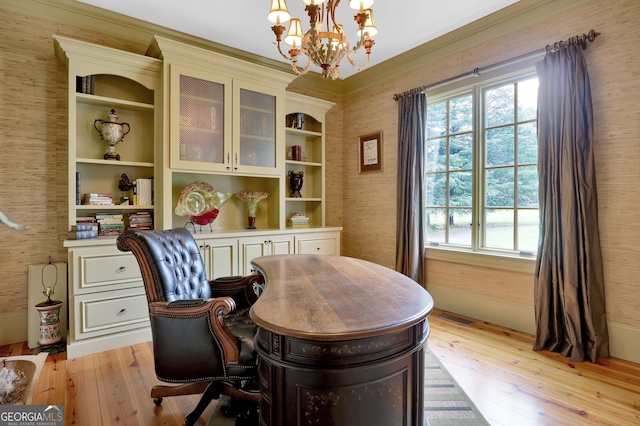 office space with light wood-type flooring, built in shelves, and a notable chandelier