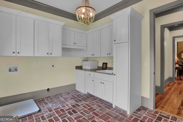 interior space with crown molding, dark hardwood / wood-style floors, white cabinets, and decorative light fixtures