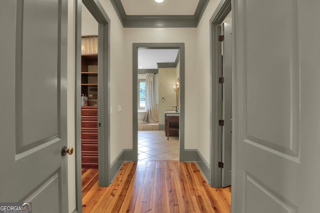 hallway with crown molding and light tile patterned floors