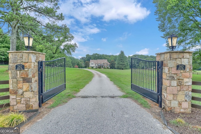 view of gate with a yard