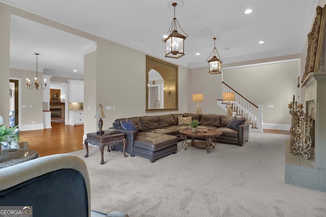 living room featuring an inviting chandelier, carpet, and ornamental molding