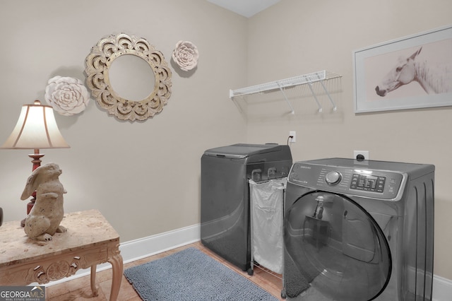 laundry room with light hardwood / wood-style floors and washing machine and dryer