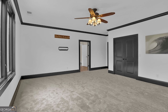 spare room with carpet flooring, ornamental molding, and ceiling fan