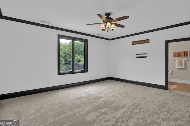 carpeted spare room with crown molding and ceiling fan