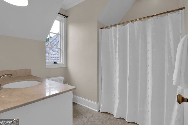 bathroom with tile patterned flooring, vaulted ceiling, and vanity