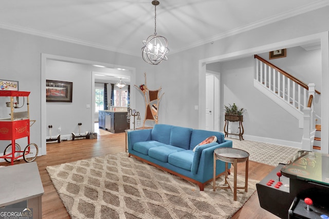 living room with wood-type flooring, a notable chandelier, and ornamental molding