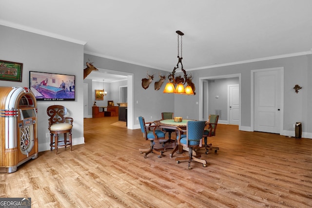 dining area featuring light hardwood / wood-style floors, a chandelier, and ornamental molding