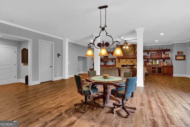 dining space featuring ceiling fan with notable chandelier, light hardwood / wood-style floors, and crown molding