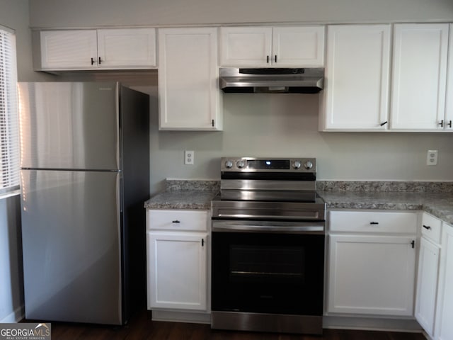 kitchen featuring white cabinets, dark wood-type flooring, light stone counters, and appliances with stainless steel finishes