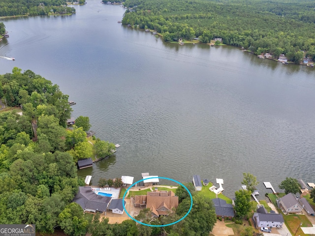 drone / aerial view featuring a water view and a forest view