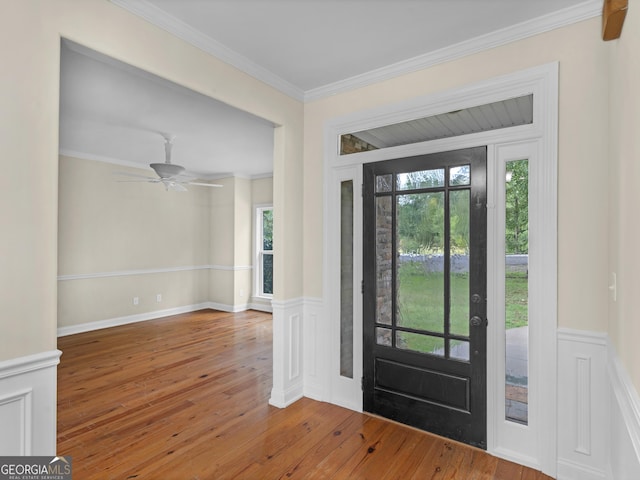 entryway featuring ceiling fan, hardwood / wood-style flooring, ornamental molding, and a healthy amount of sunlight