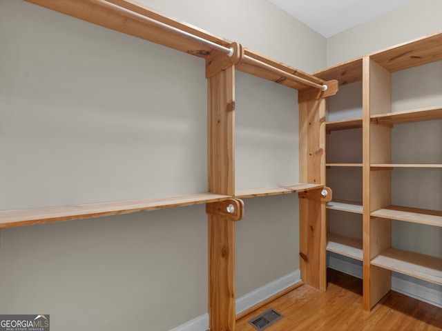 walk in closet with visible vents and wood finished floors