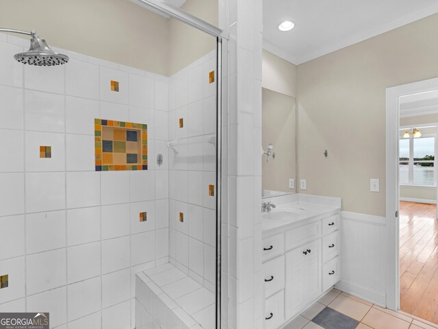 bathroom featuring crown molding, vanity, tile patterned floors, and walk in shower