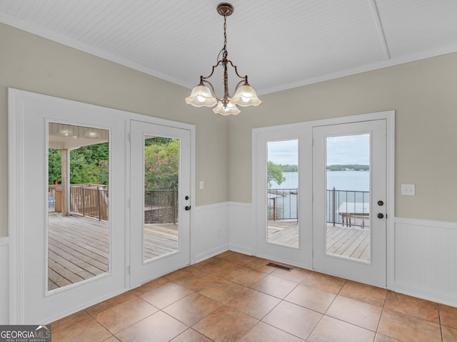 entryway featuring a water view, visible vents, wainscoting, and an inviting chandelier