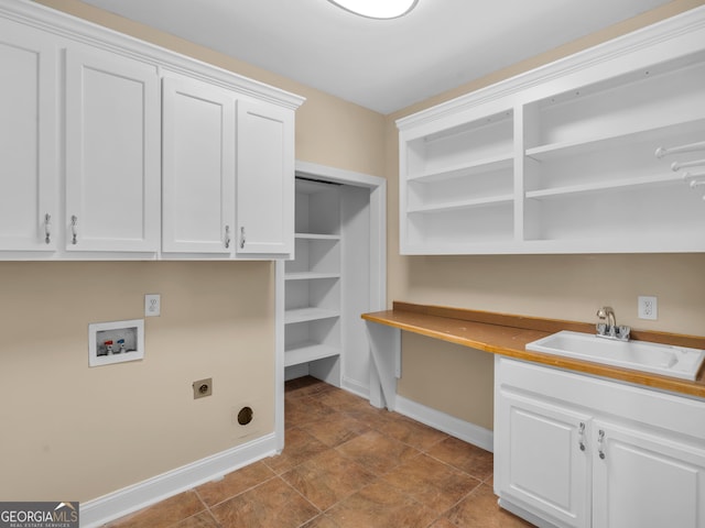 washroom with cabinet space, a sink, hookup for a washing machine, baseboards, and hookup for an electric dryer