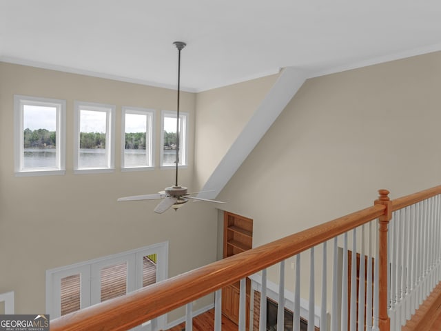 interior details featuring a ceiling fan, ornamental molding, and a water view